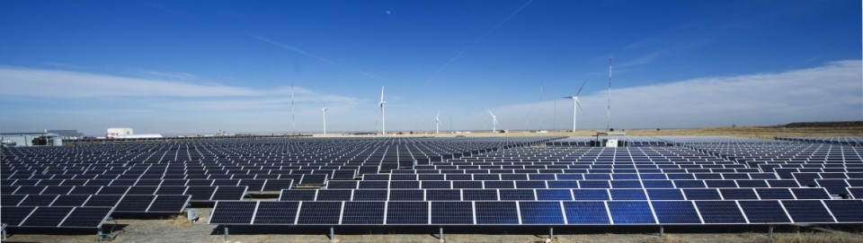 Rows of photovoltaic panels with sky in background.